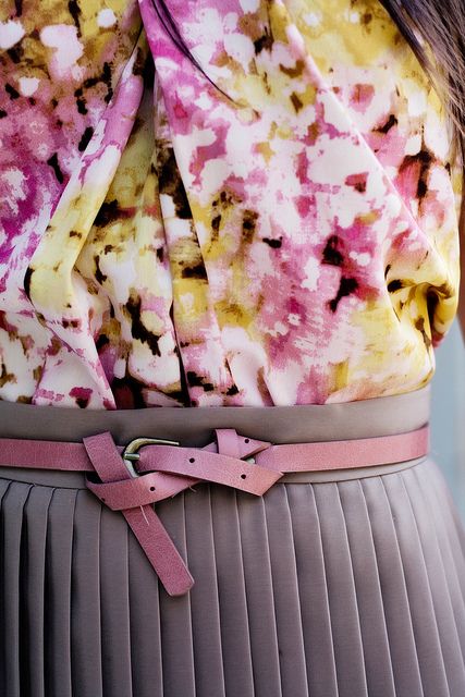 Artful knot with a blouse and knife pleat skirt.